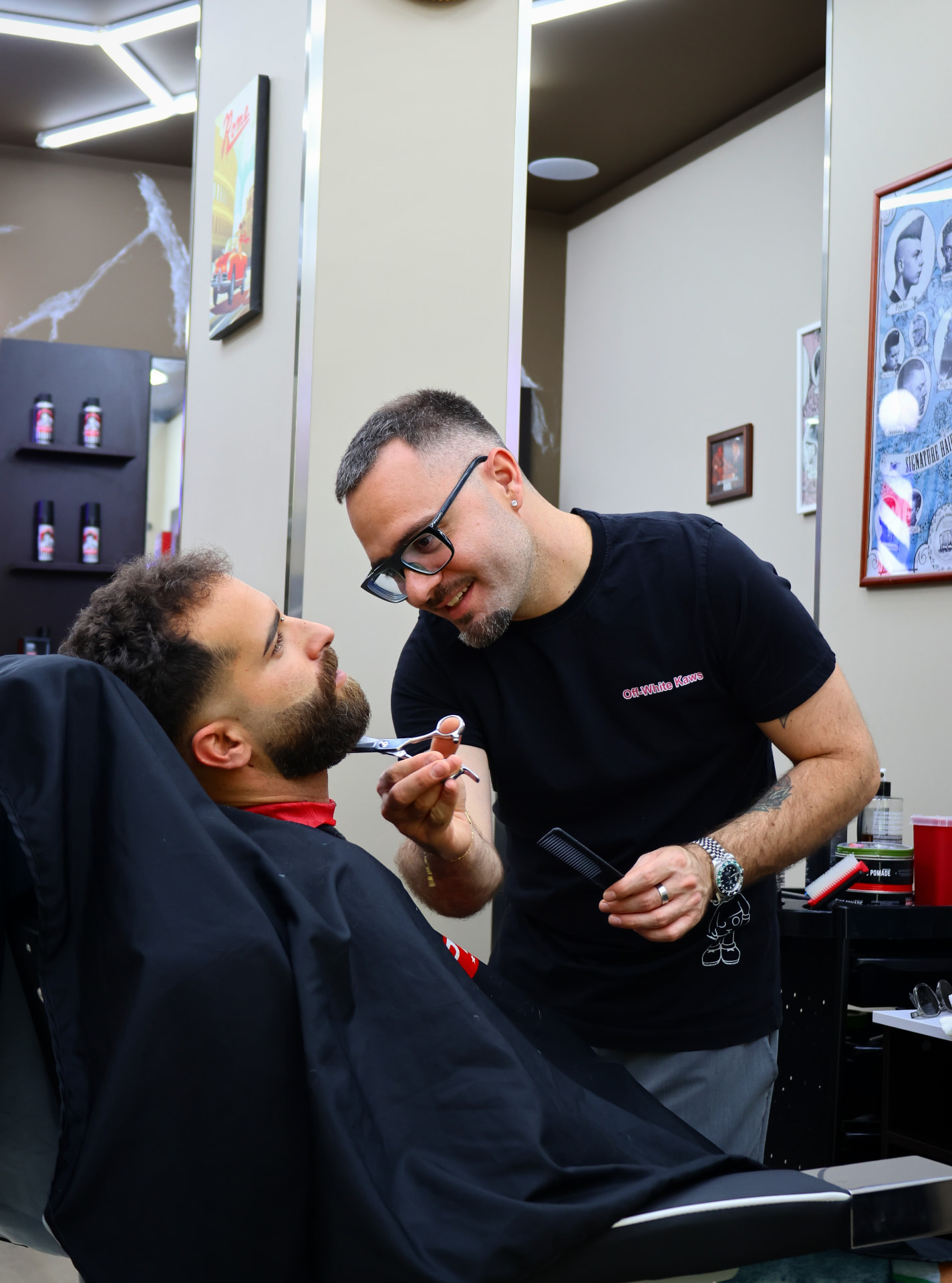 Giuseppe Schittino mentre rifinisce la barba di un cliente nel salone